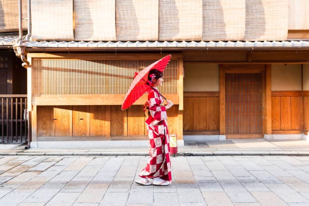 Woman in red kimono with parasol walking Gion lane — Kyoto