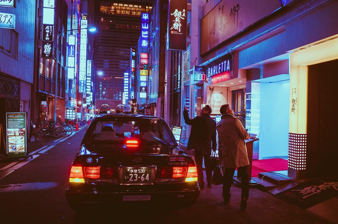 Neon-lit Japanese street at night with taxi — Osaka nightlife