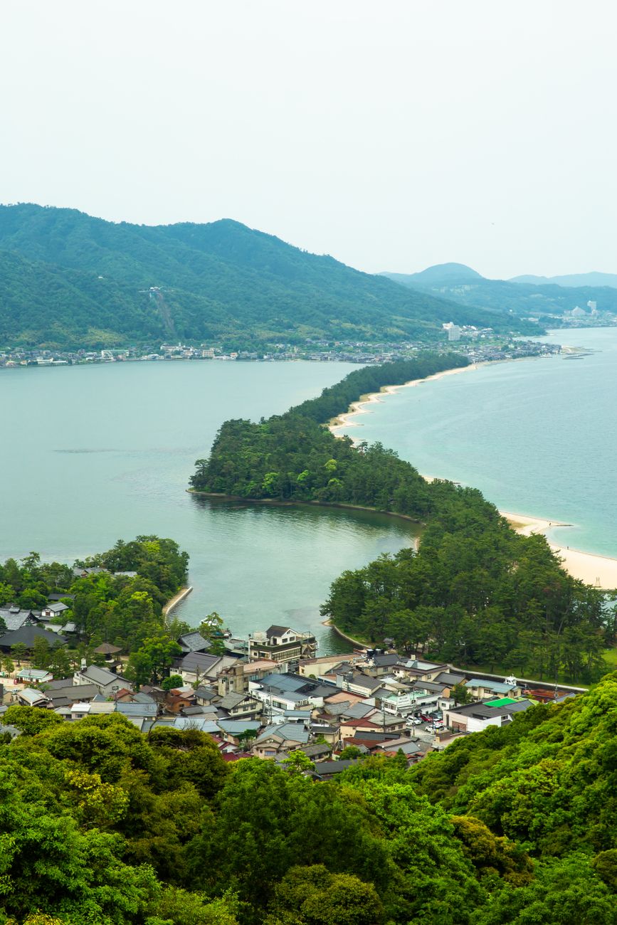 Amanohashidate pine-covered sandbar curving across Miyazu Bay, seen from the hillside viewpoint above Monju
