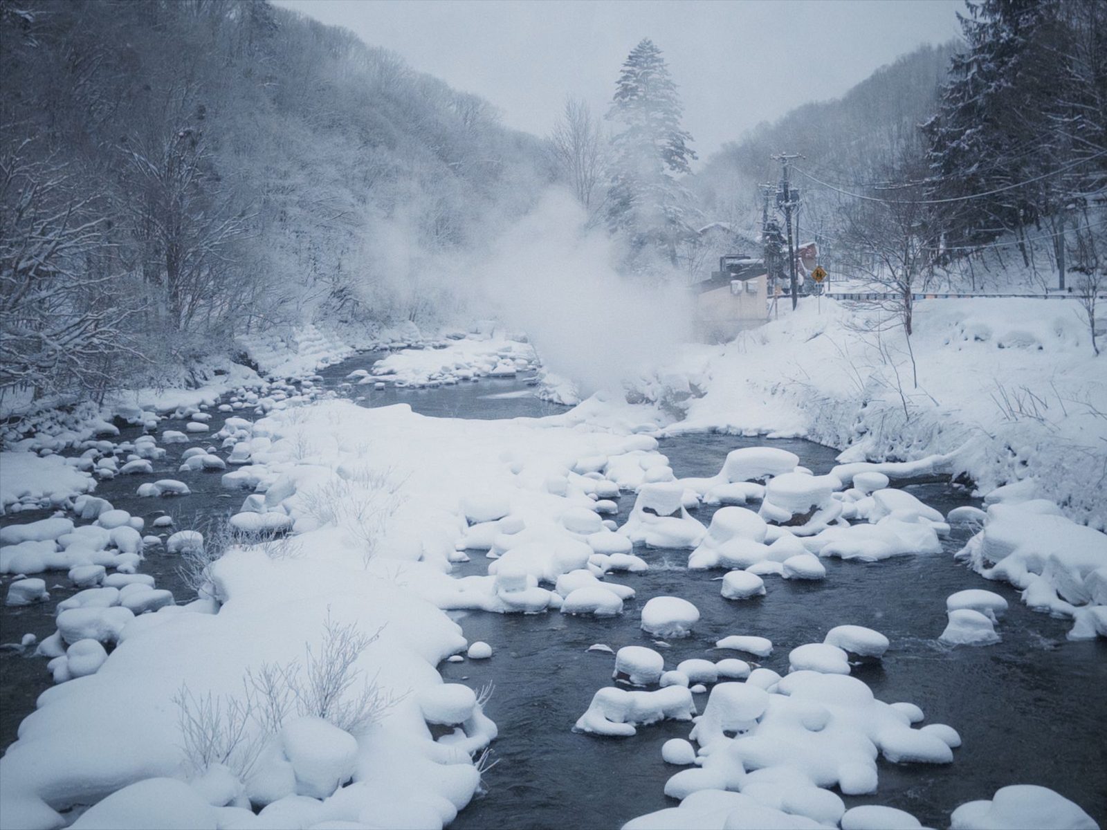 Illustrative photo: Peaceful snowy river landscape with steam rising in a tranquil winter setting.
