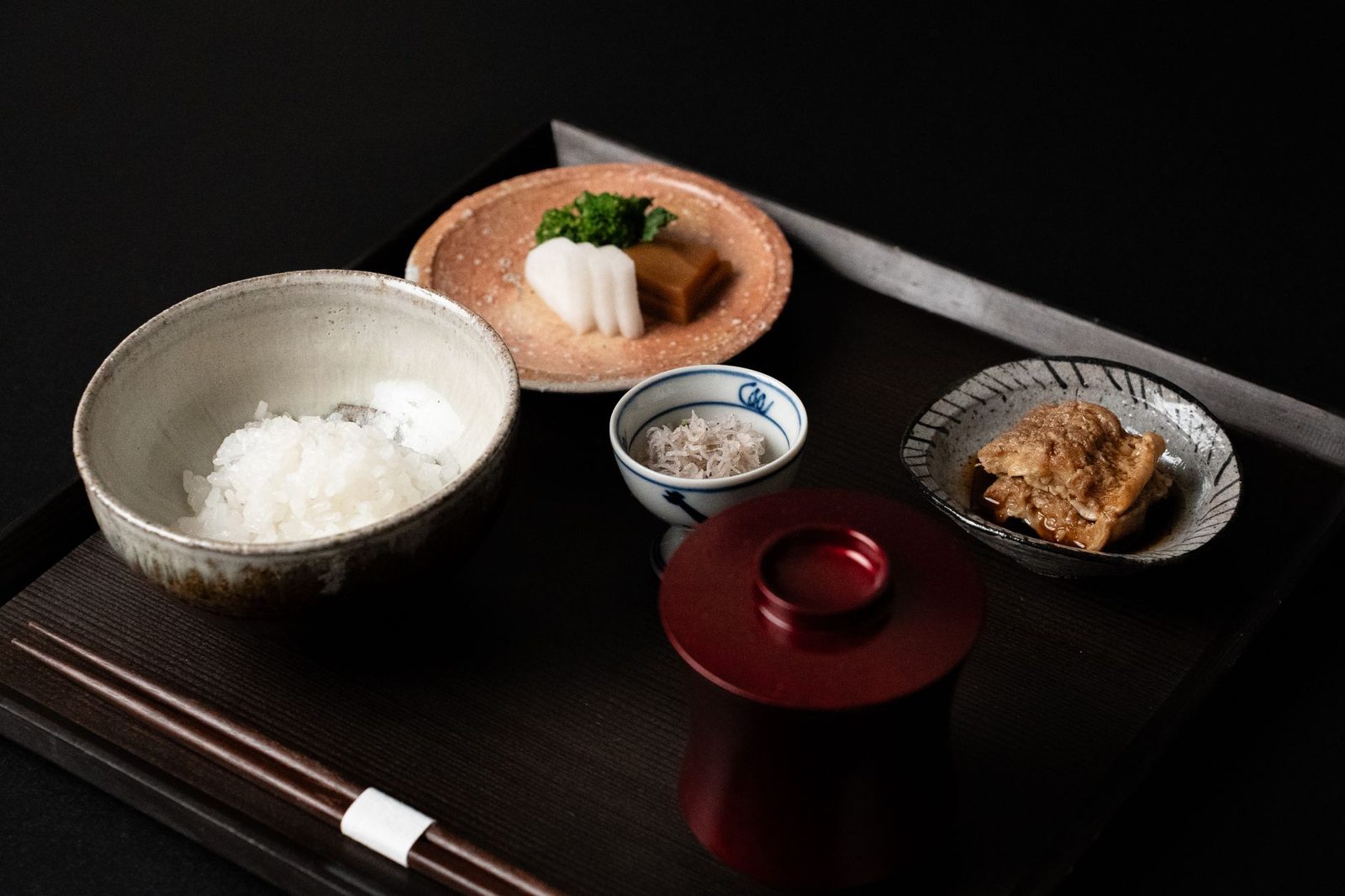 Illustrative photo: Traditional Japanese breakfast with rice, fish, and pickles served on a tray.