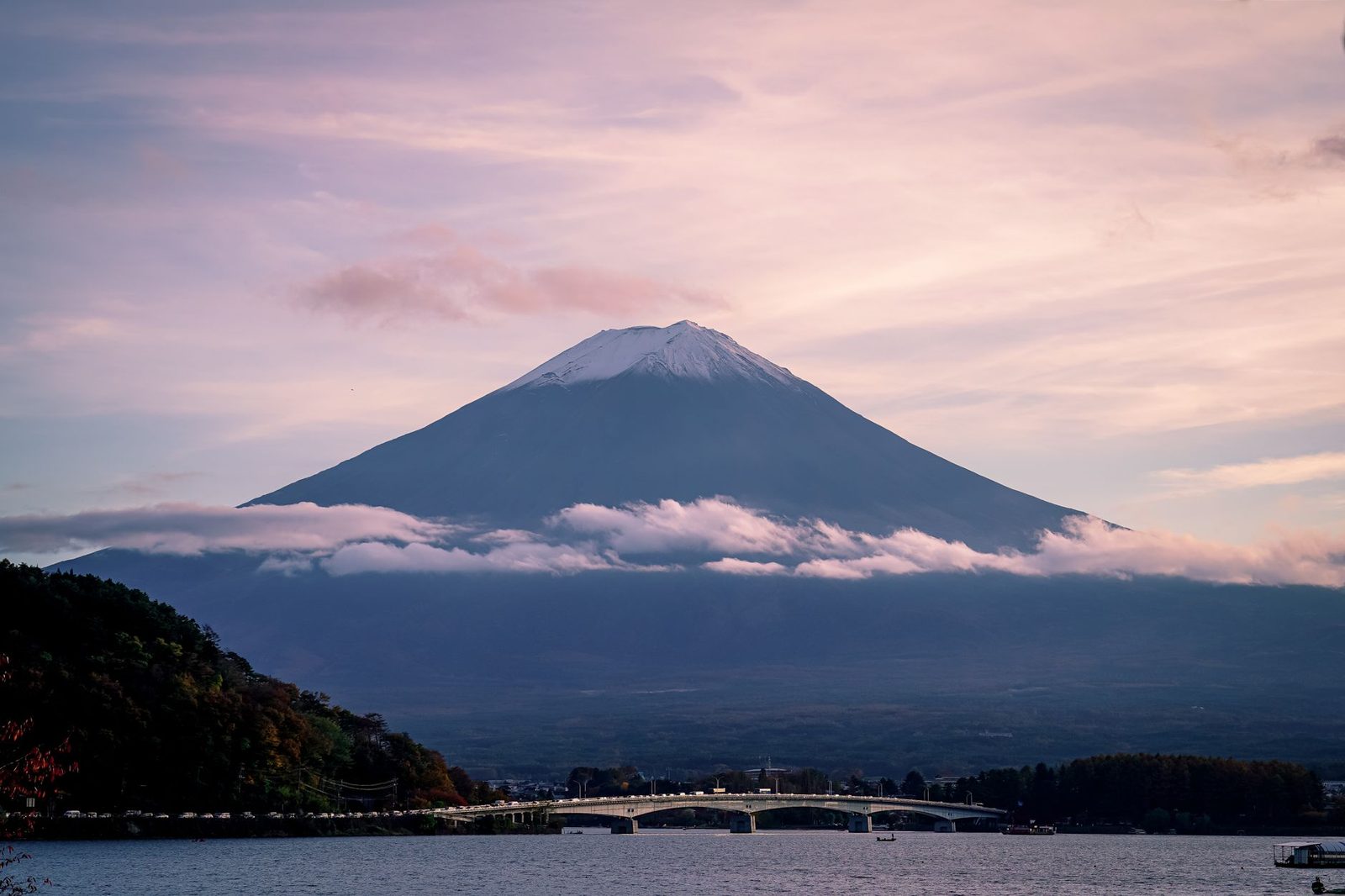 Illustrative photo: A breathtaking view of Mount Fuji with delicate clouds and serene waters beneath a pastel sky.