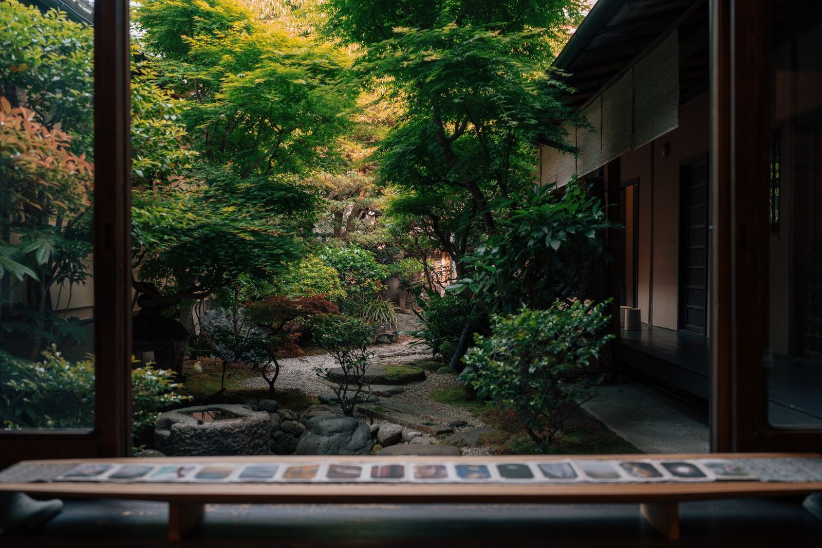 Illustrative photo: Serene view of a traditional Japanese Zen garden in Kyoto from indoors, showcasing lush greenery and tranquility.